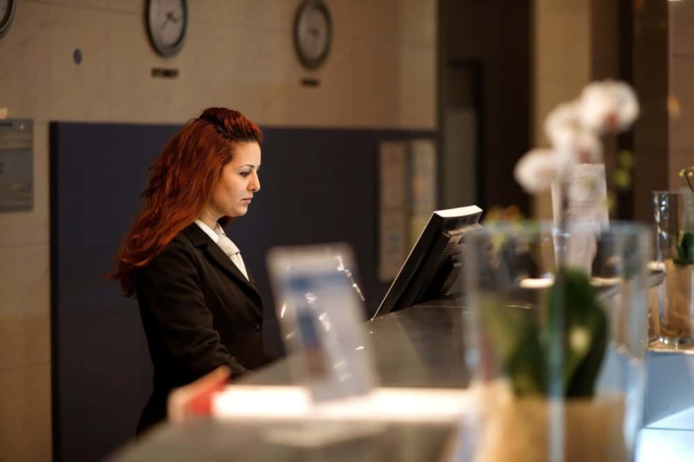 photo of hotel concierge with a woman at the desk using the computer